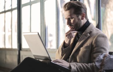 Mann guckt verwundert auf sein Laptop