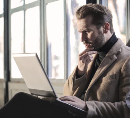 Mann gukct verwirrt auf sein Laptop