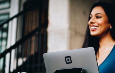 Frau mit Laptop lächelt