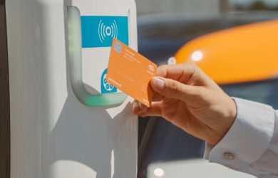 Person bezahlt mit Bezahlkarte an der Ladesäule für E-Auto