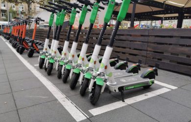 Lime E-Scooter stehen nebeneinander auf der Straße