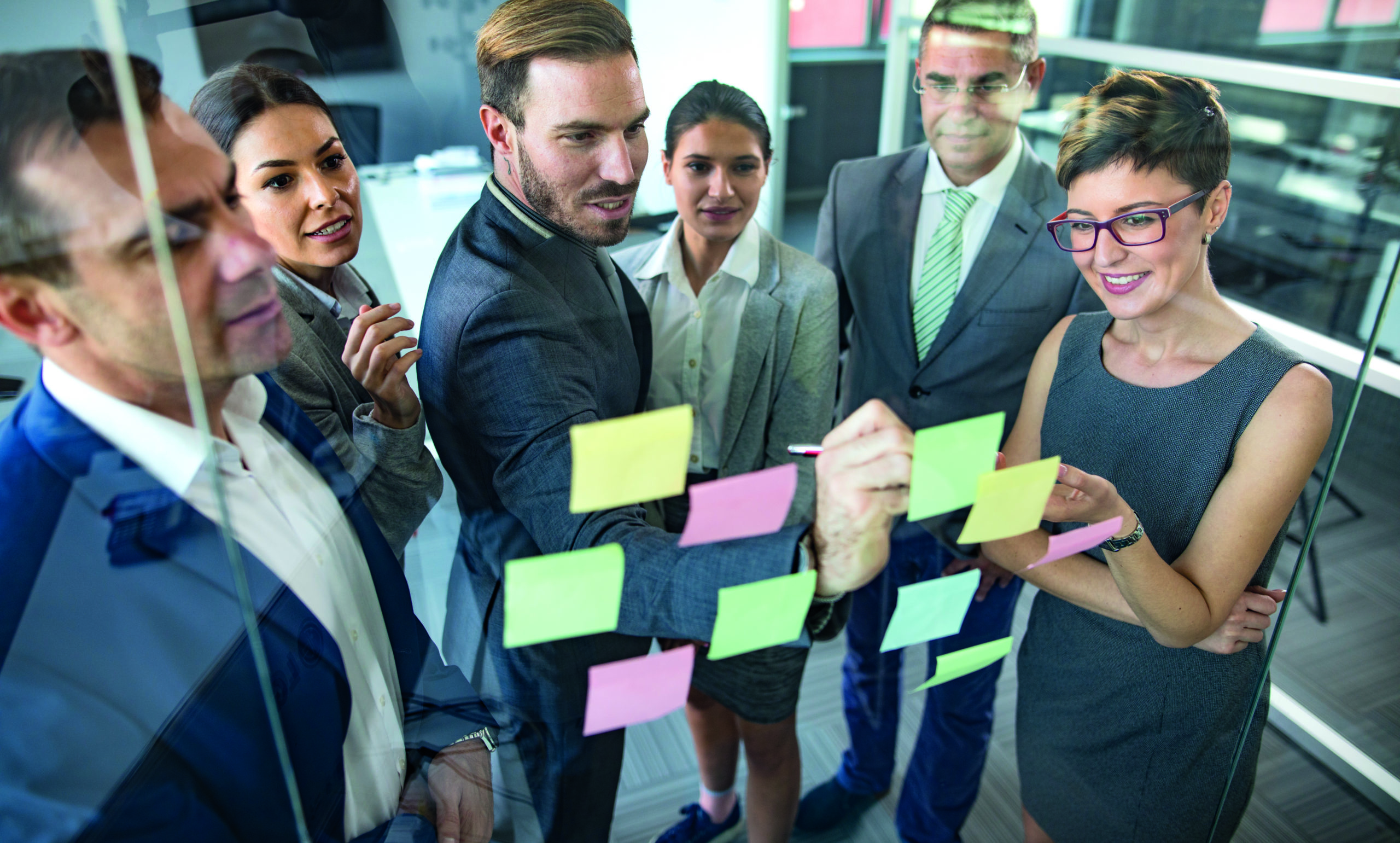 Eine Gruppe von Geschäftsleuten gemischten Alters sitzt im Büro und arbeitet an innovativen Geschäftsideen.