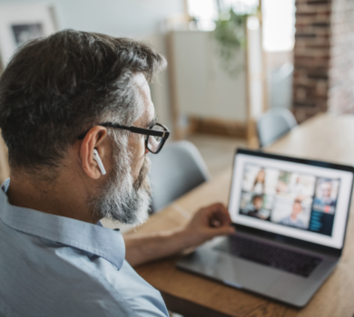 Mann mit Airpods in den Ohren beteiligt sich an einem Online Call im Home Office teilnimmh