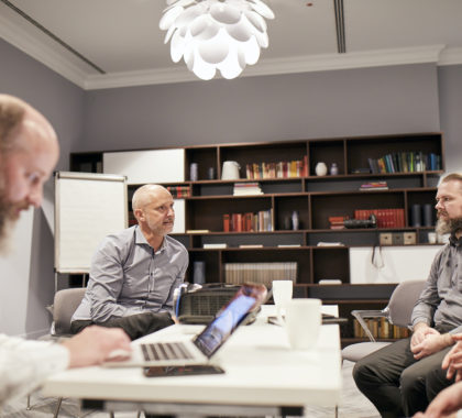 3 Kollegen in einer Besprechung am Arbeitstisch im Büro