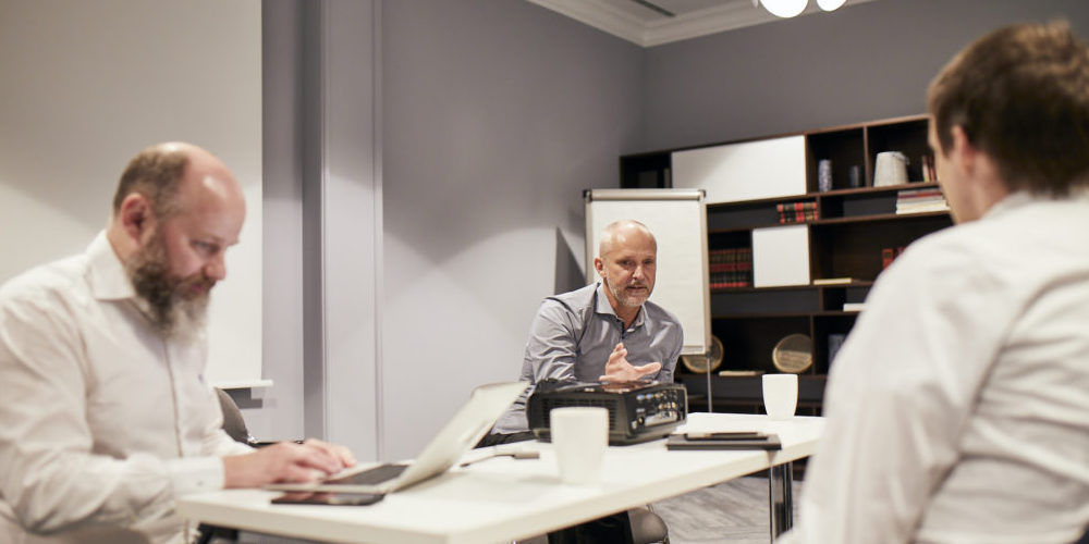 Drei Consileon Mitarbeiter sind in einem Meeting im Büro.