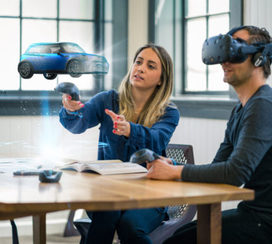 Geschäftskollegen prüfen mit einem Virtual-Reality-Headset Designkonzepte für Autos.