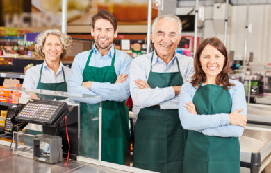 vier Arbeiter, die durch IT gestützte Personaleinsetzplanung angestellt wurden, stehen an der Kasse