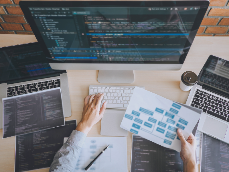 Entwickler arbeitet an Softwarecode und Architekturdiagrammen – Darstellung für IT-Beratung und Entwicklung von Webportalen