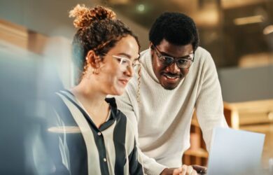 Zwei Kollegen arbeiten gemeinsam am Laptop, symbolisch für CRM Trends im Jahr 2026