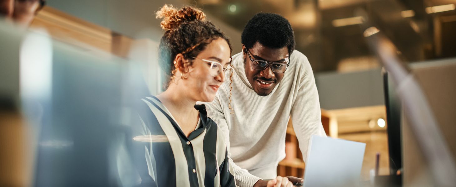 Zwei Kollegen arbeiten gemeinsam am Laptop, symbolisch für CRM Trends im Jahr 2026